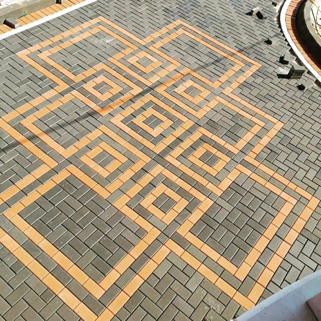 Circular mosaic paving pattern around a potted palm